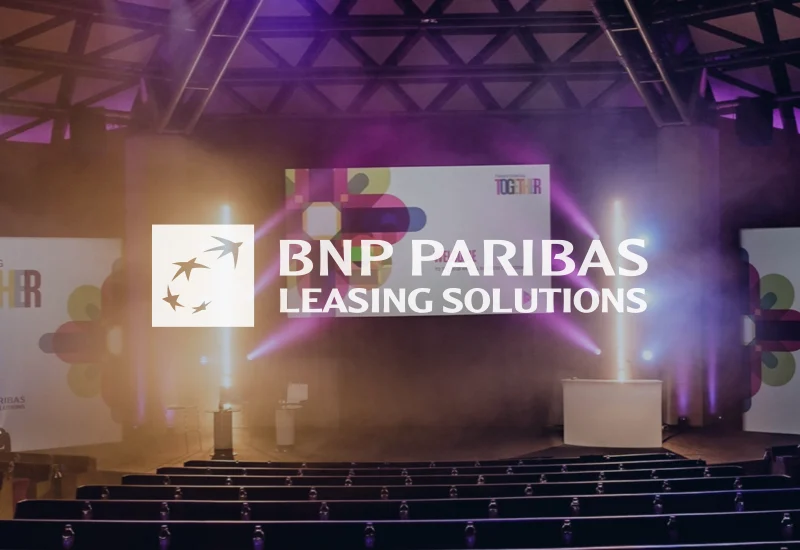 Stage set for a corporate conference for BNP Paribas with bright lights and event-themed screens.